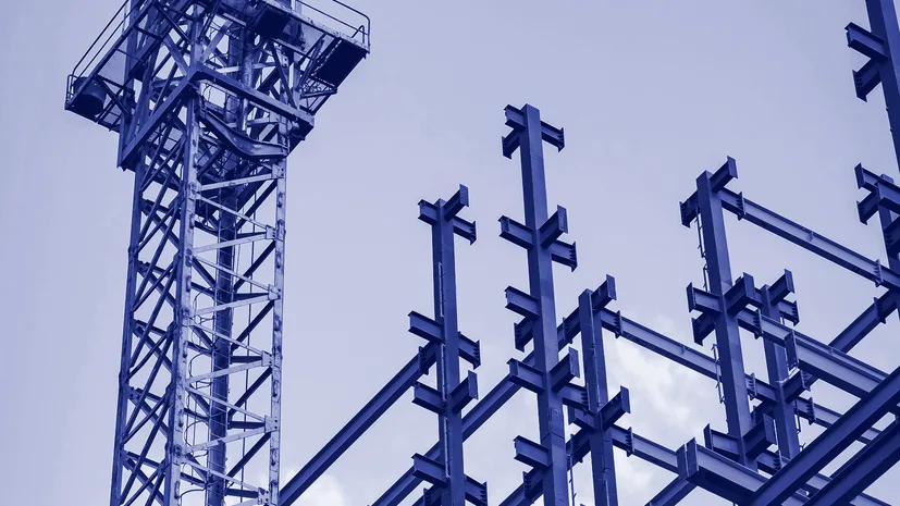 A tower crane above the steel frame of an unfinished building